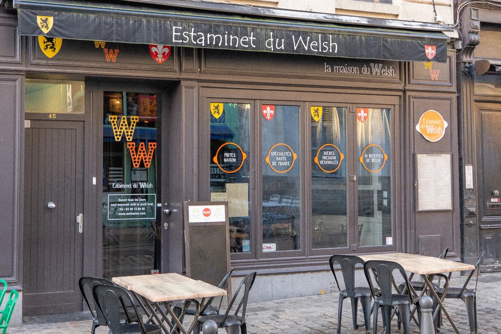 L'entrée de l'Estaminet du Welsh, cadrage resserré sur la porte et l'ardoise du jour.